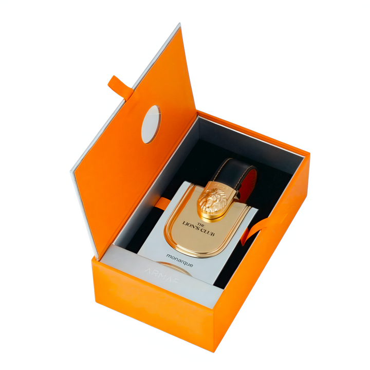 Perfume bottle with gold cap in an open orange box on a white background