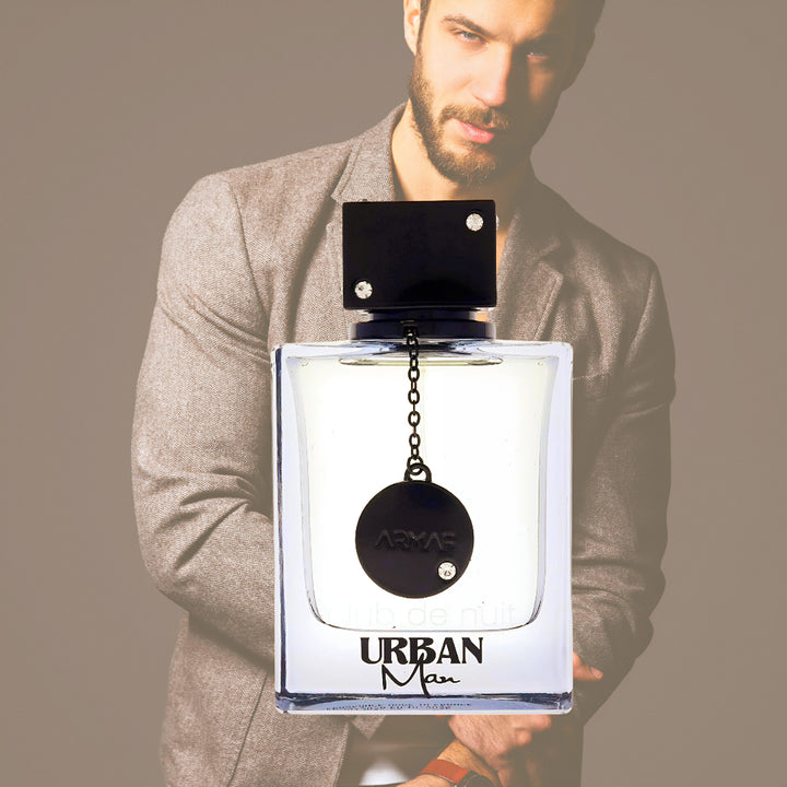 Man holding a large 'Urban Man' perfume bottle with a blurred background