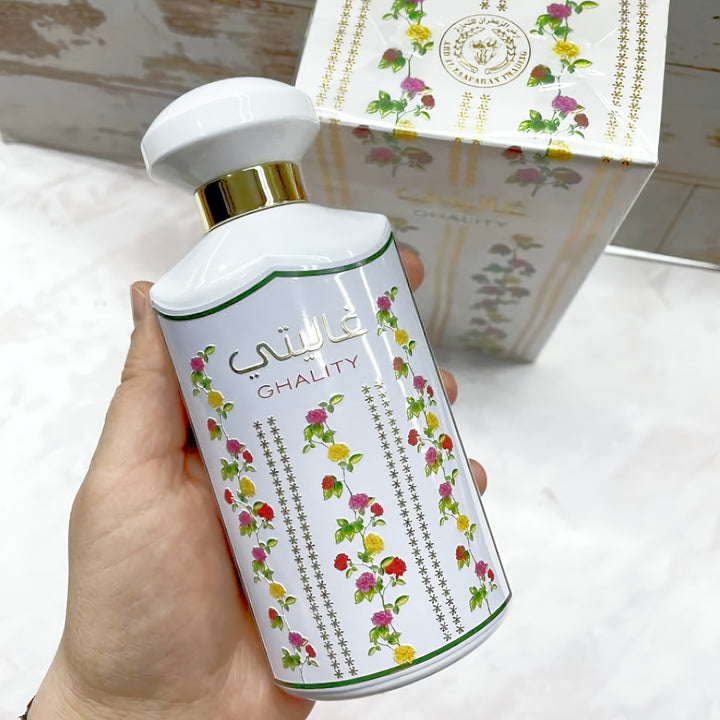 Hand holding a white bottle with floral design and 'Ghality' branding, with a matching box in the background.