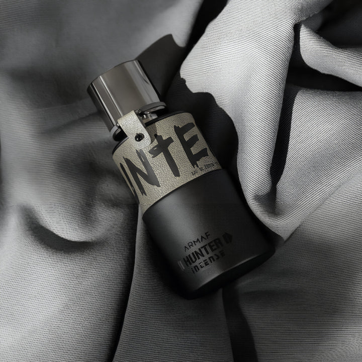 Perfume bottle with visible brand name on a textured fabric background Hunter Intense Armaf for men
