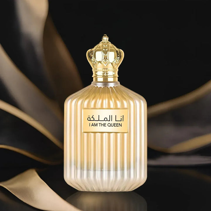 Perfume bottle labeled 'I Am The Queen' with gold accents on a dark background