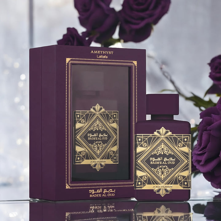 Purple perfume bottle and packaging with gold designs, surrounded by purple roses. Bade'e Al Oud Amethyst Lattafa Perfumes for women and men
