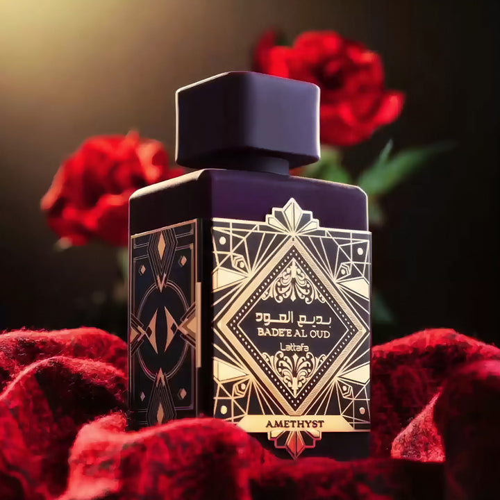 Perfume bottle with intricate design on a dark background with red roses Bade'e Al Oud Amethyst Lattafa Perfumes for women and men

