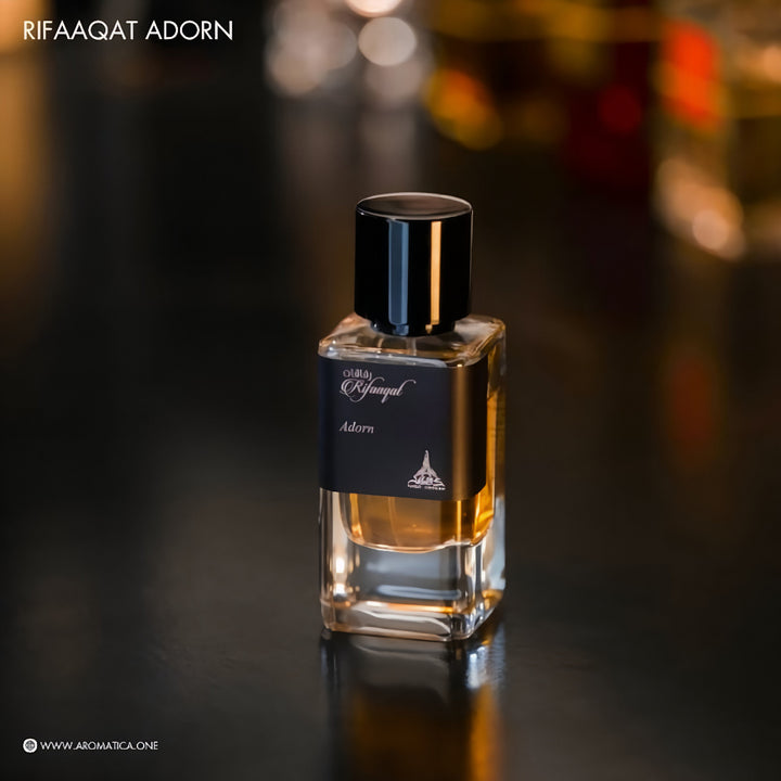 Perfume bottle with black cap on a dark surface, blurred background Rifaaqat Adorn 85ml EDP – Unisex Woody Chypre Perfume by Paris Corner