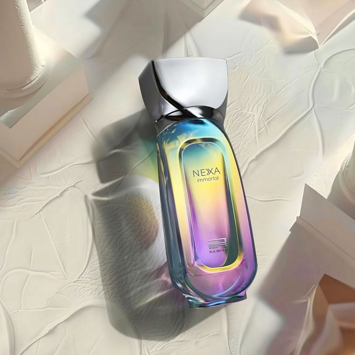 Nexa Immortal Rue Brocaperfume bottle with iridescent design on a textured surface