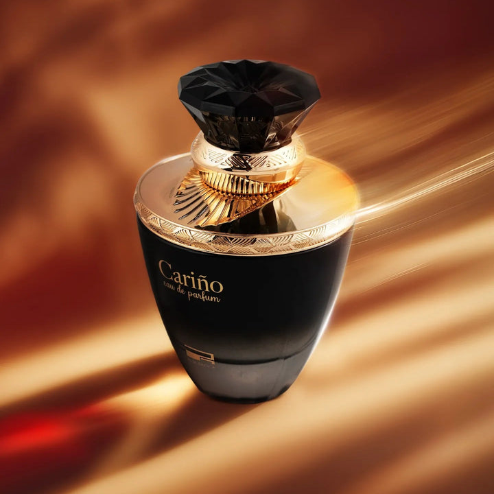 Black and gold perfume bottle with 'Cariño' branding on a warm brown background