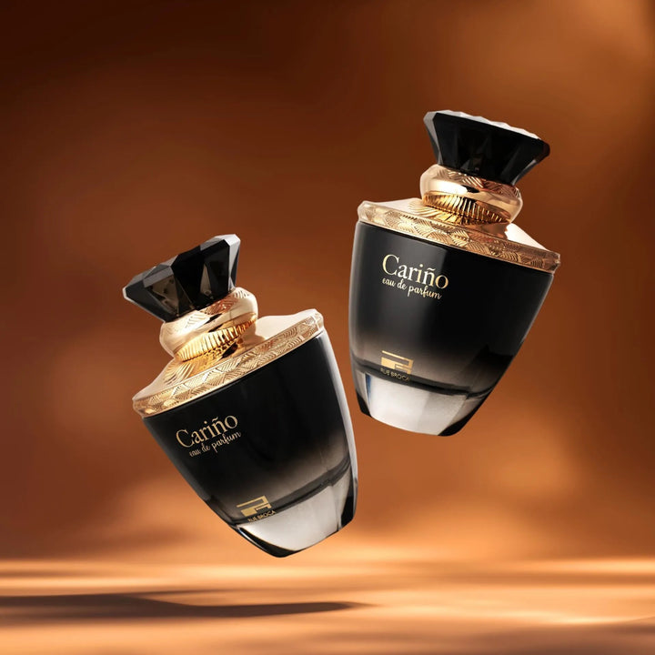 Two black and gold perfume bottles with 'Carina' branding on a brown background