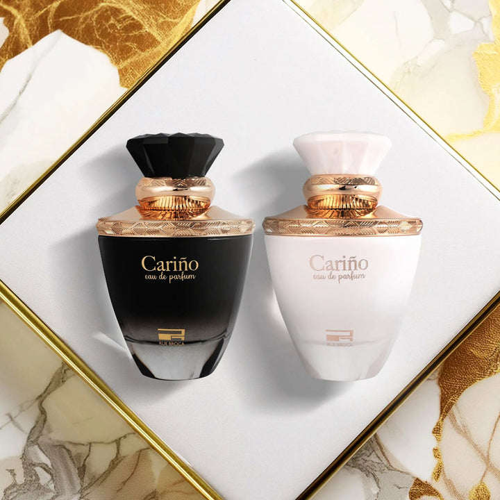 Two Cariño perfume bottles, one black and one white, on a decorative background.