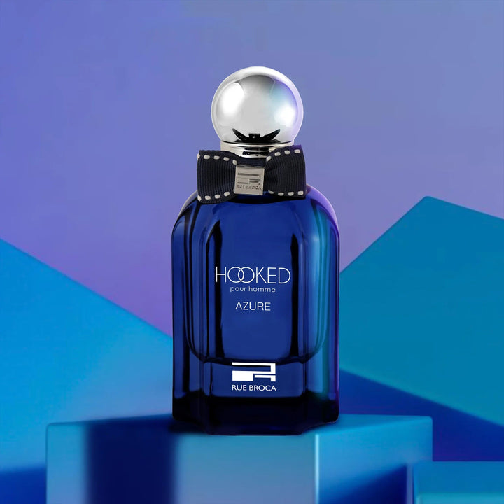 Blue perfume bottle with silver cap on a blue and purple geometric background