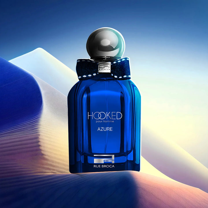 Blue perfume bottle labeled 'Hooked Azure' by Rue Broca against a gradient background