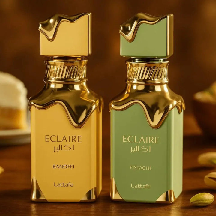 Two Eclaire perfume bottles, one gold and one green, on a wooden surface with pistachios and cookies.