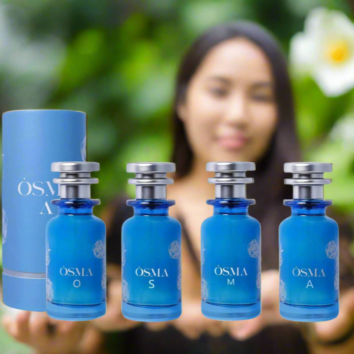 Set of blue perfume bottles with silver caps on a reflective surface, against a sky background.