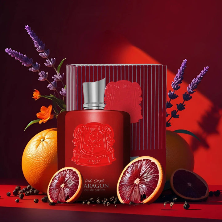 Red Aragon perfume bottle with packaging, oranges, and lavender on a red background