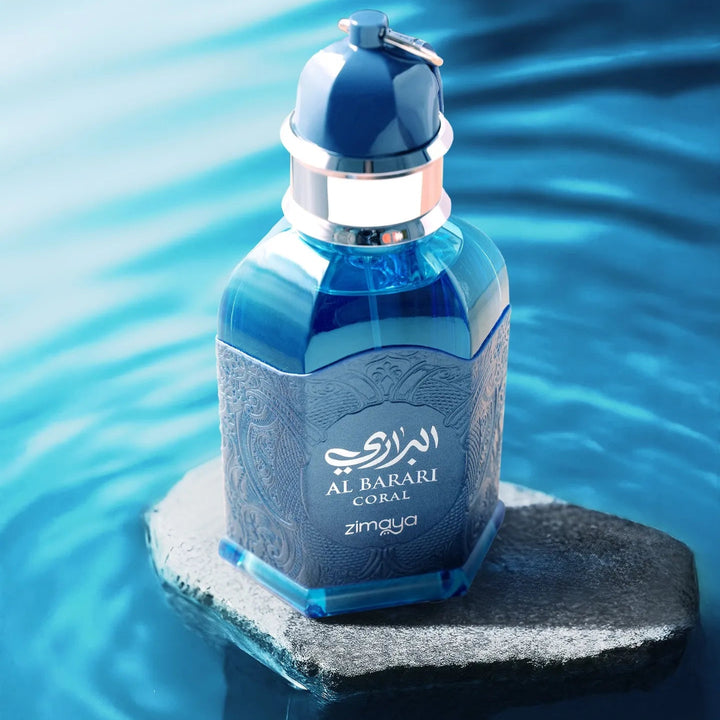 Blue perfume bottle with 'Al Barari' branding on a rock with water in the background